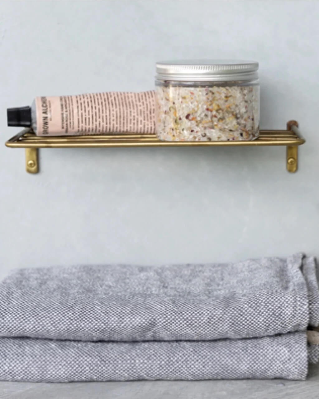 A solid brass wire wall shelf for bathroom or kitchen storage.