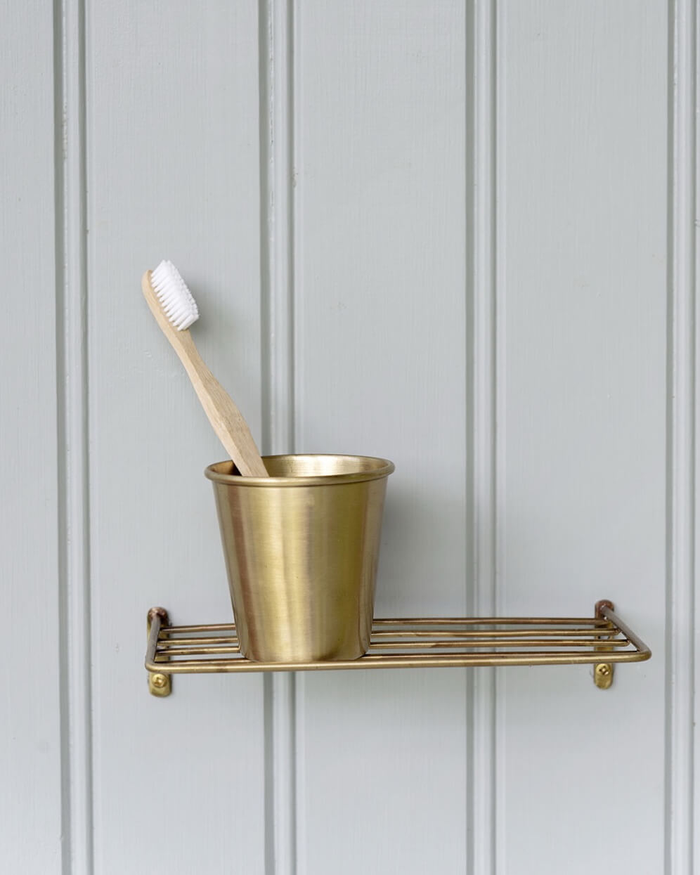 A solid brass wire wall shelf for bathroom or kitchen storage.