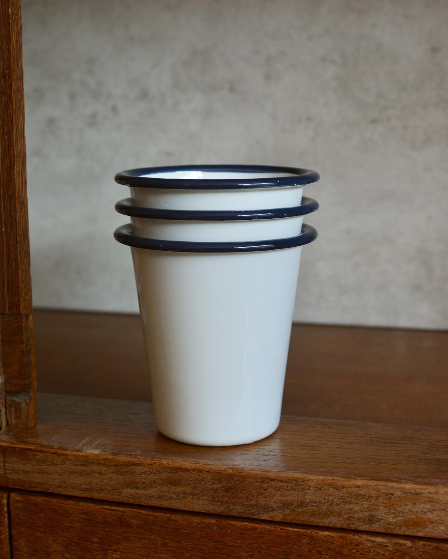 Stackable classic white enamel beakers with navy rim.