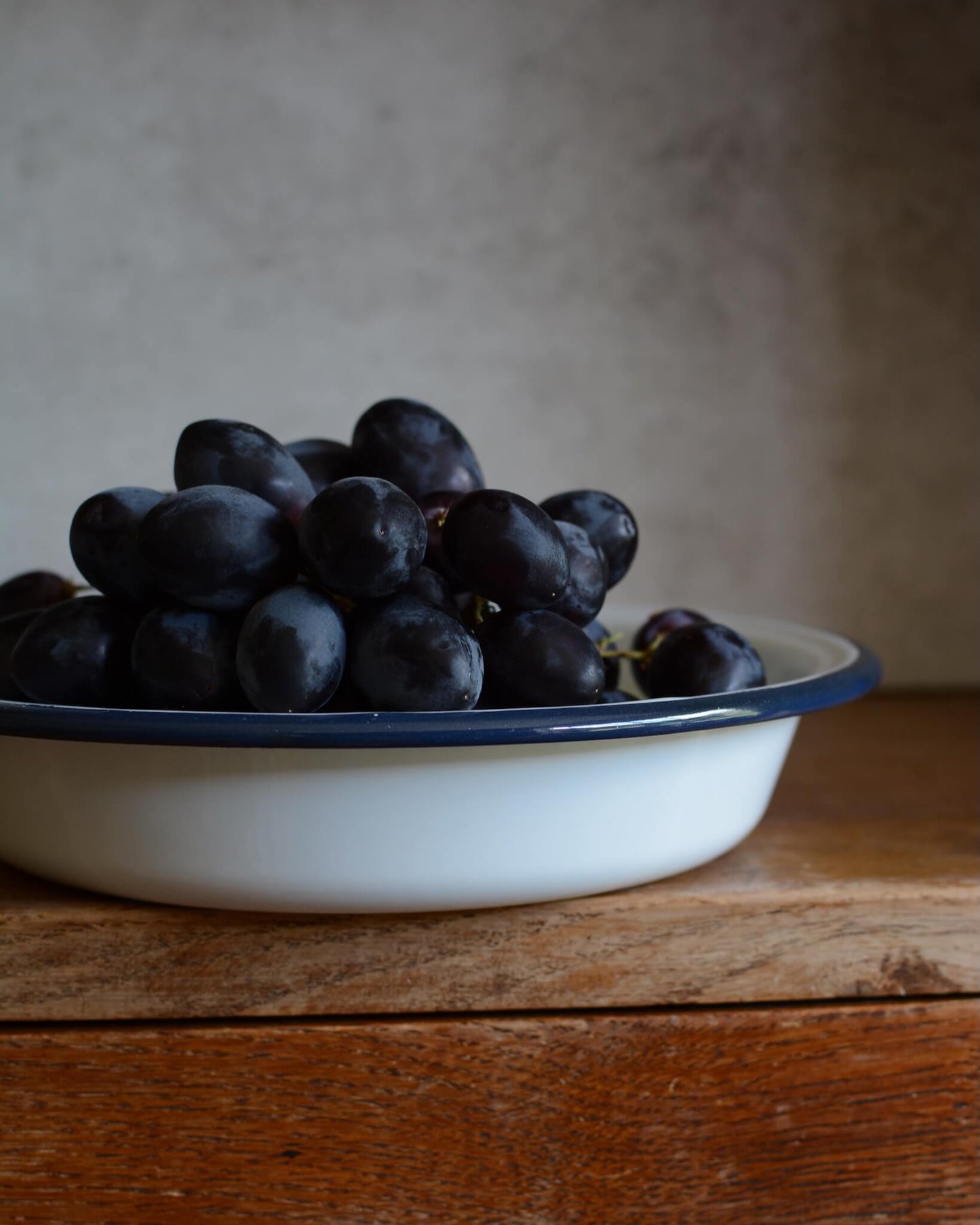 Classic white enamel serving dish or fruit bowl, shown here with grapes.