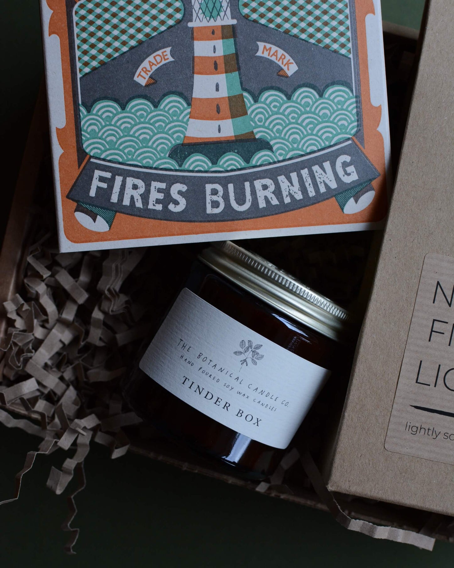 Gift box, containing an amber jar candle, box of matches with a lighthouse design and a pack of natural firelighters.