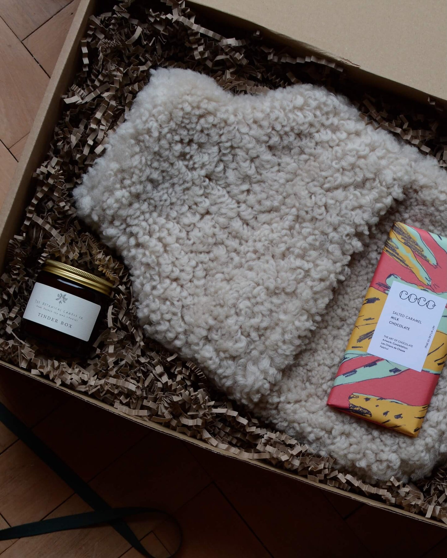 An example of a gift box, containing a sheepskin hot water bottle, chocolate bar and jar candle.