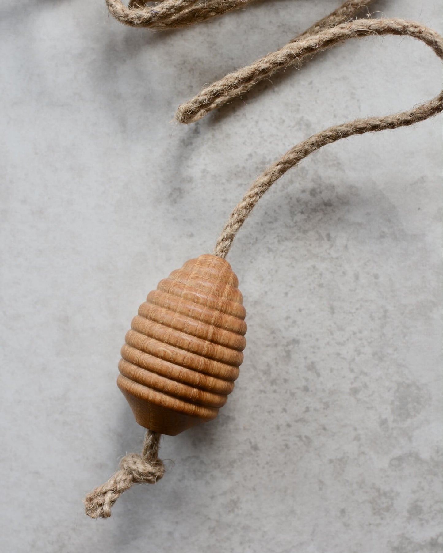 Detail shot of a turned oak light pull in a beehive shape.