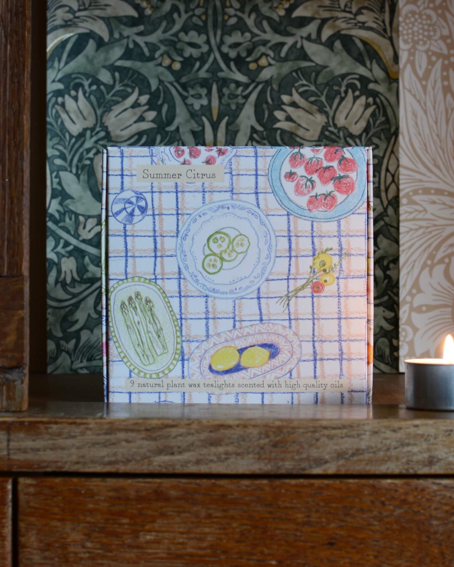 An illustrated box of tea lights with an illustration of a summer tablescape.