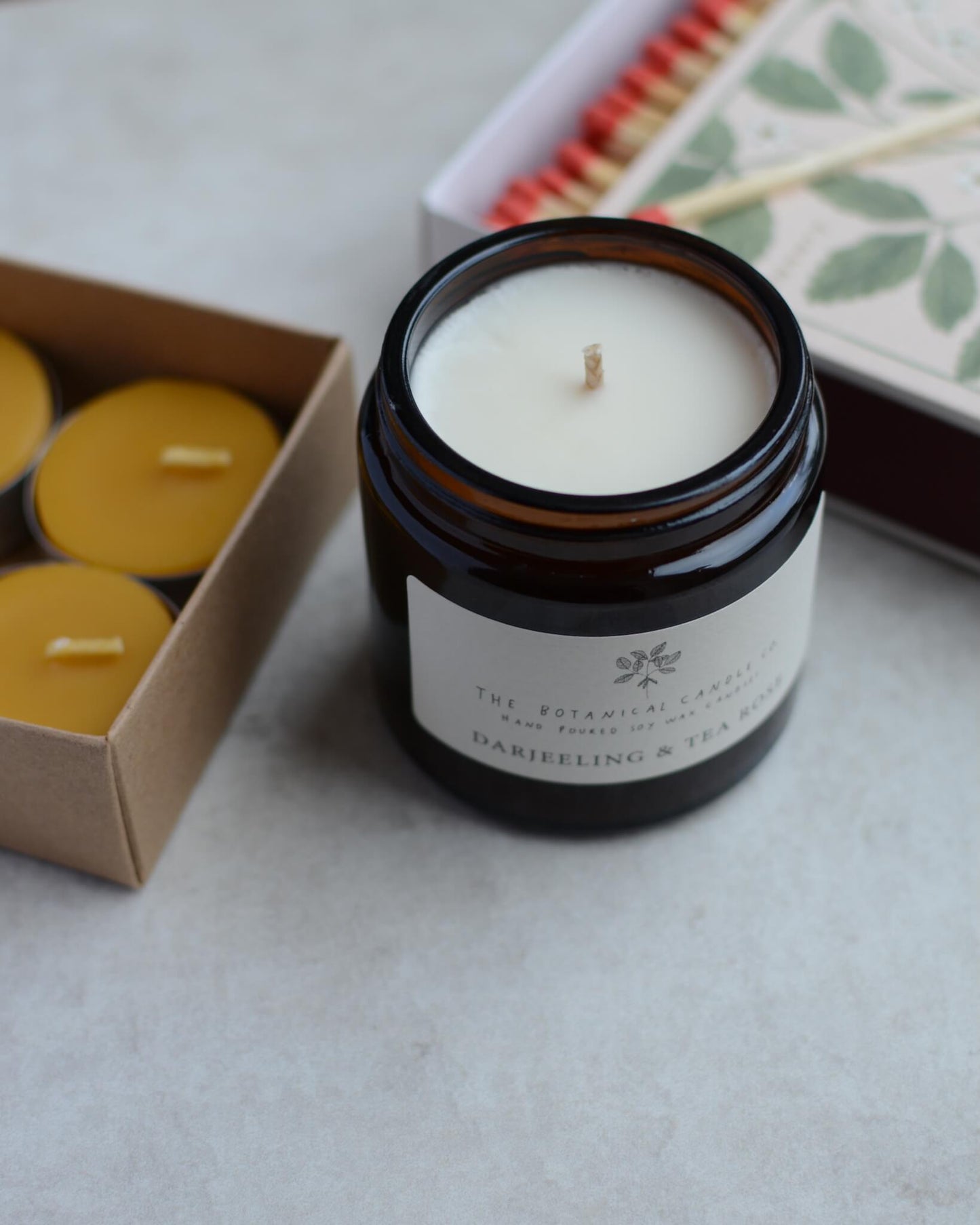 A candle gift box containing a scented rose candles, 4 beeswax tea lights and a box of strawberry-design matches.