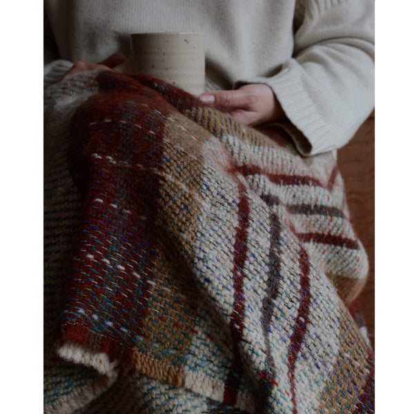 Recycled random wool blanket, shown on lap with a cup of coffee.