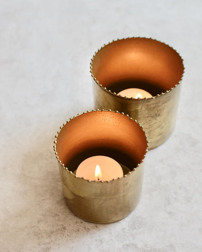 A set of 2 solid brass tea light holders, with beaded detailing around the rim. 