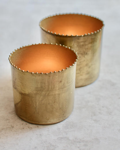A set of 2 solid brass tea light holders, with beaded detailing around the rim. 