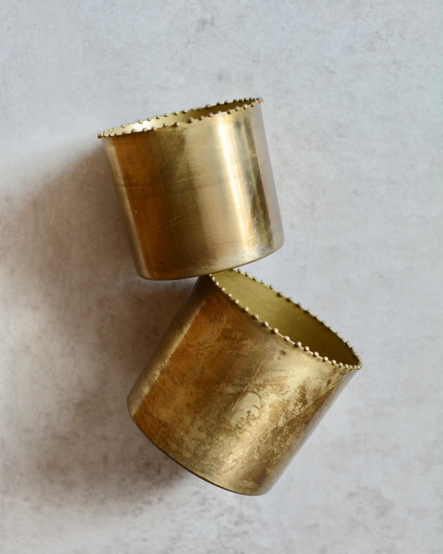 A set of 2 solid brass tea light holders, with beaded detailing around the rim. 