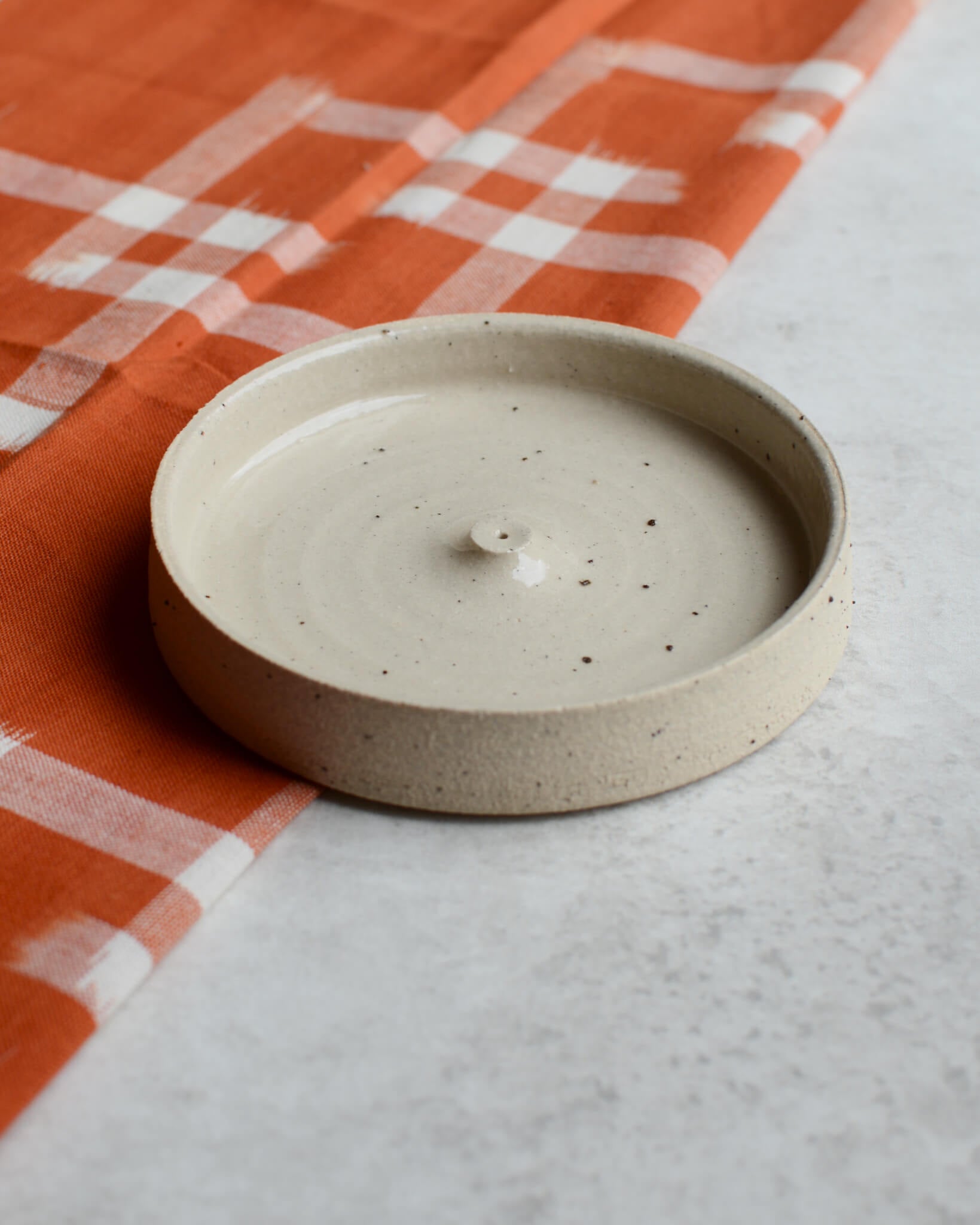 An oatmeal coloured ceramic hand-thrown incense holder.