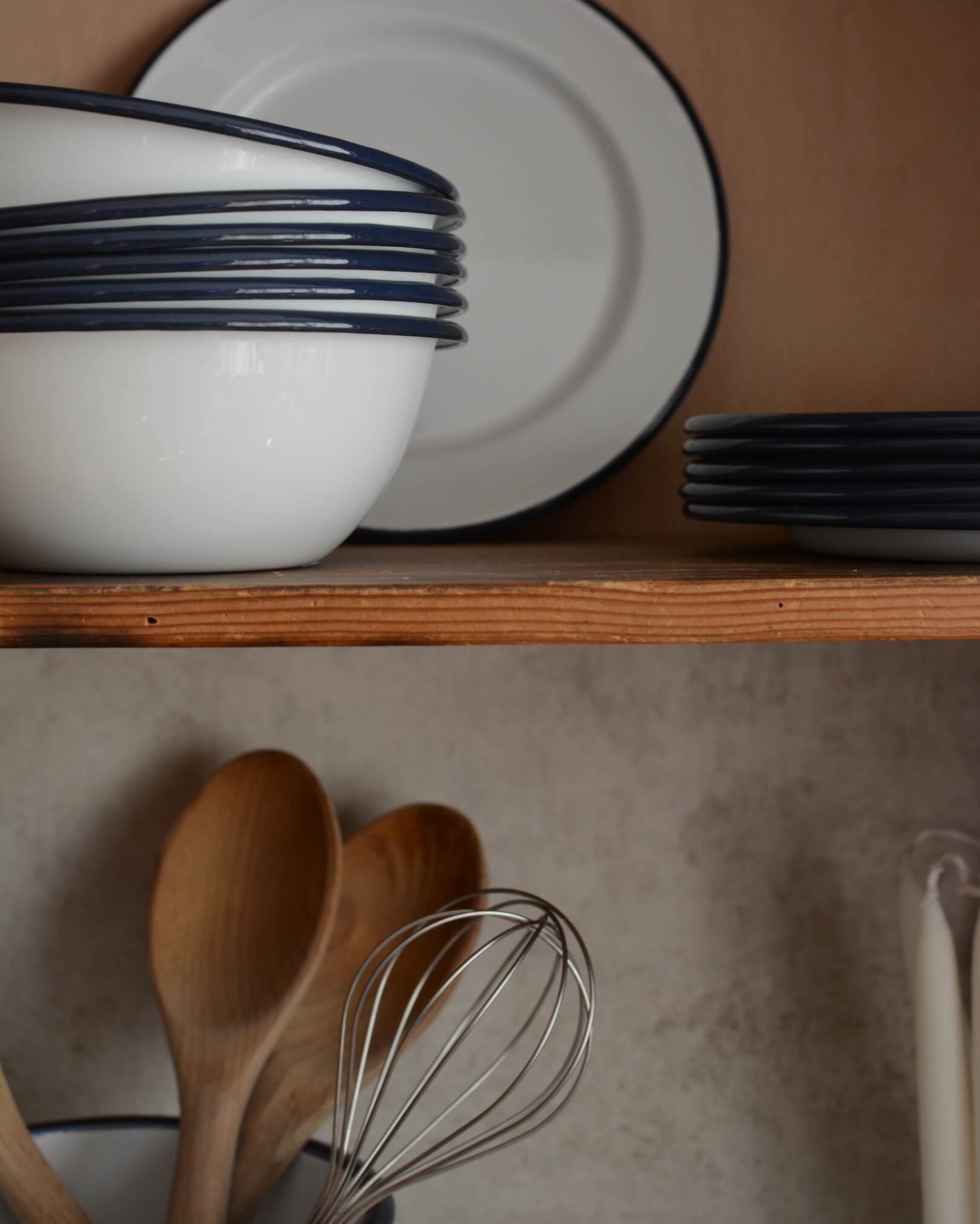 White and navy enamelware, with bowls, plates and kitchen utensils.