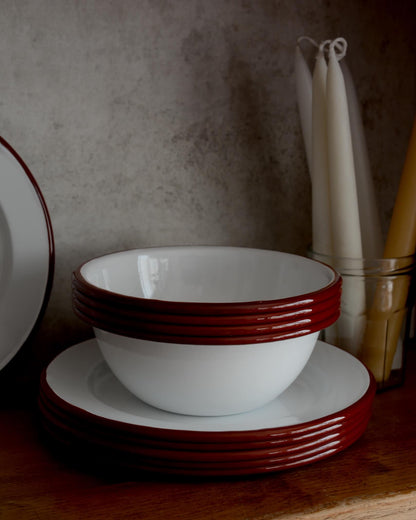A set of white and red enamel bowls and plates.
