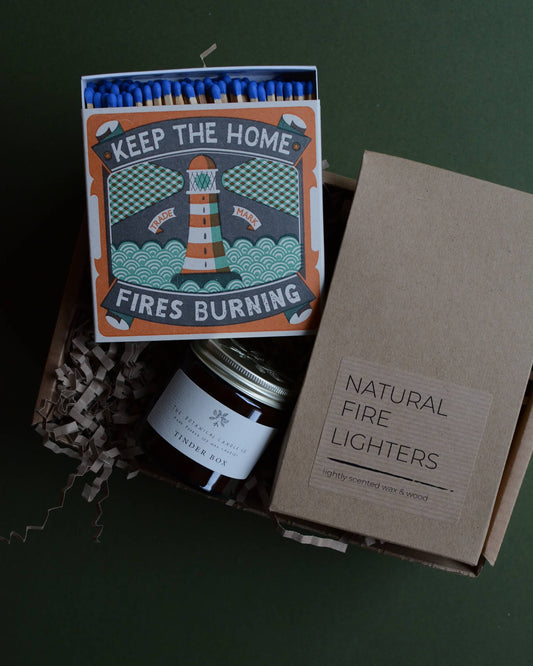 Gift box, containing an amber jar candle, box of matches with a lighthouse design and a pack of natural firelighters.