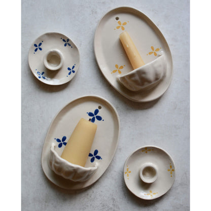 Flatlay image of ceramic candle holders and wall sconces, on top of a marble table top.