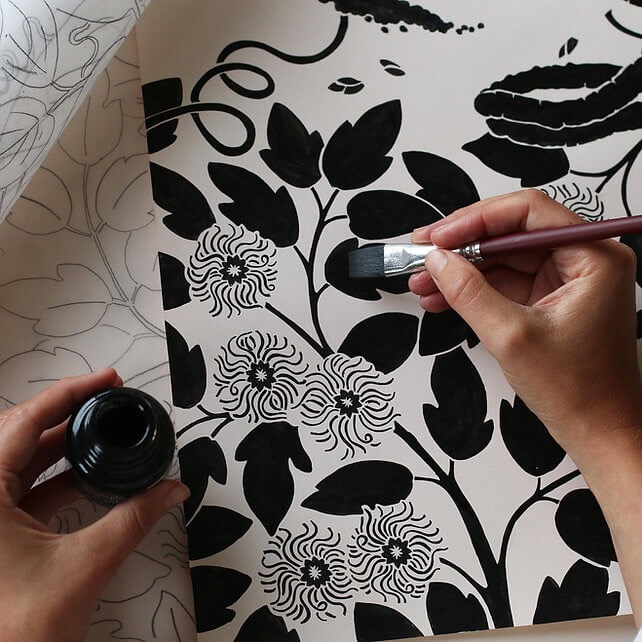 Close up of an illustrator painting a section of her botanical 2026 calendar.