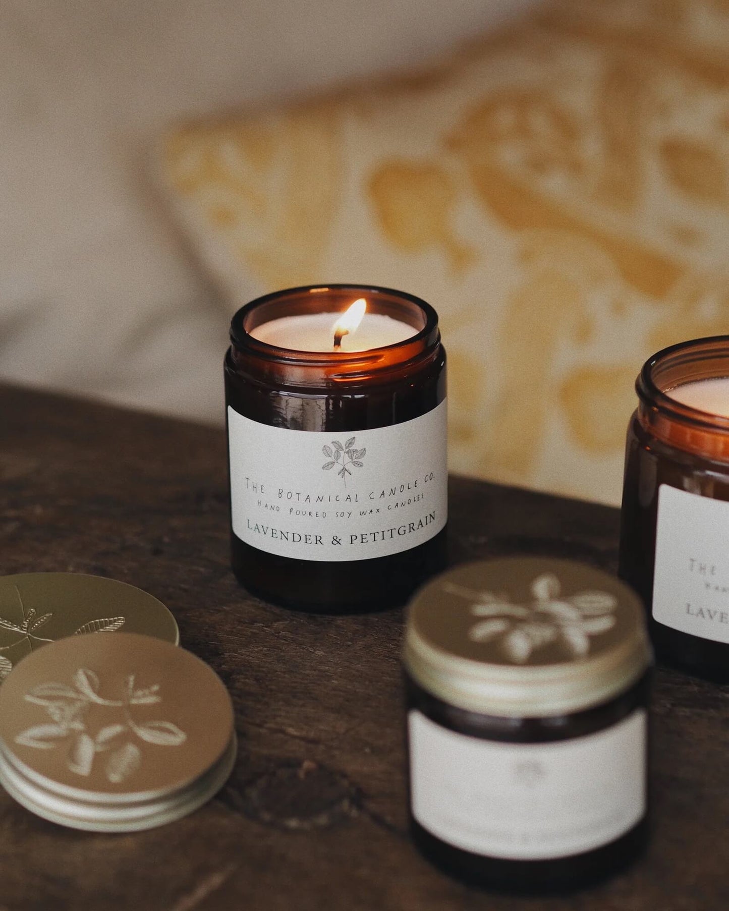 A collection of jar candles, shown on a bedside table.