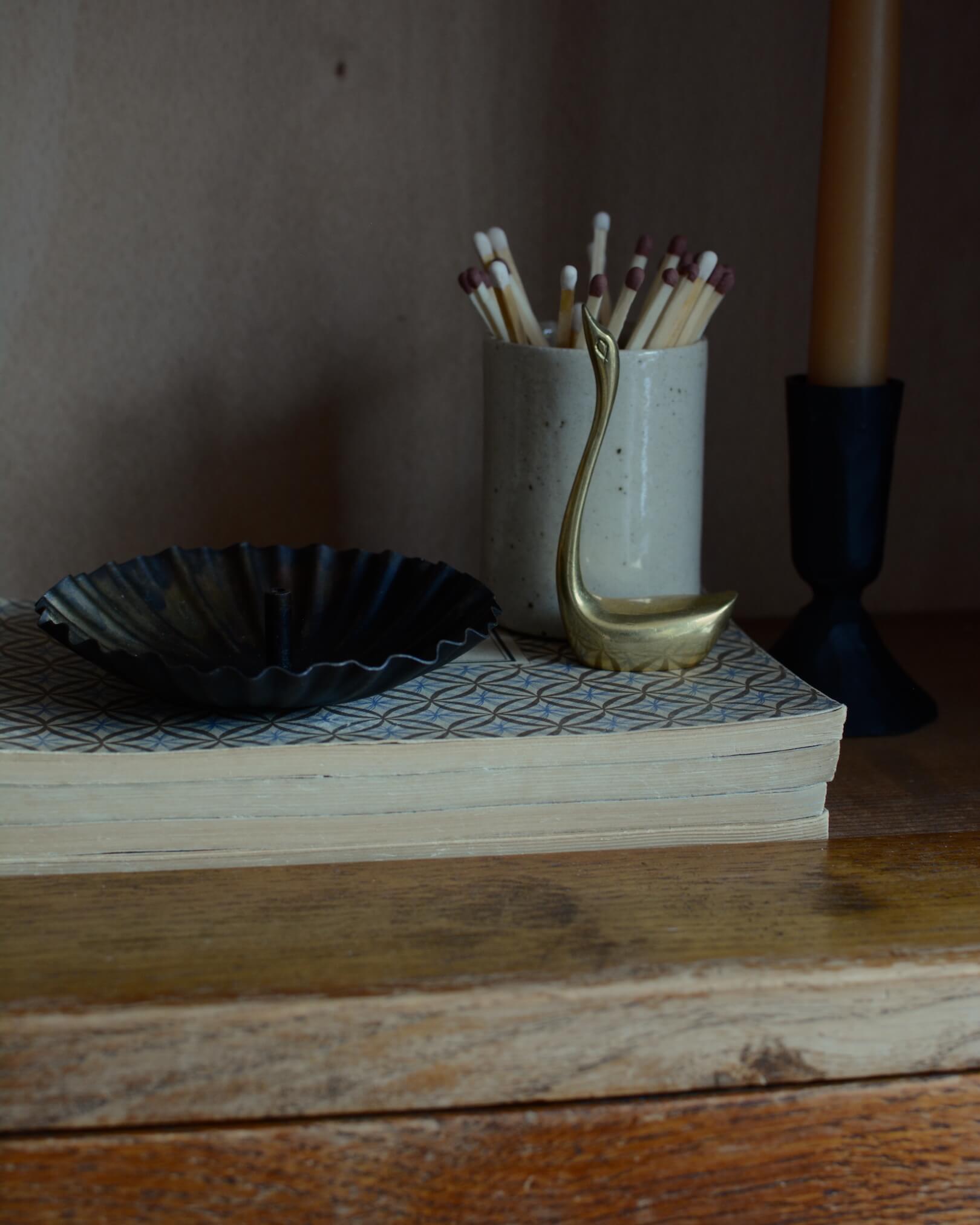 A metal incense holder in a fluted circle design, with a bronzed finish.