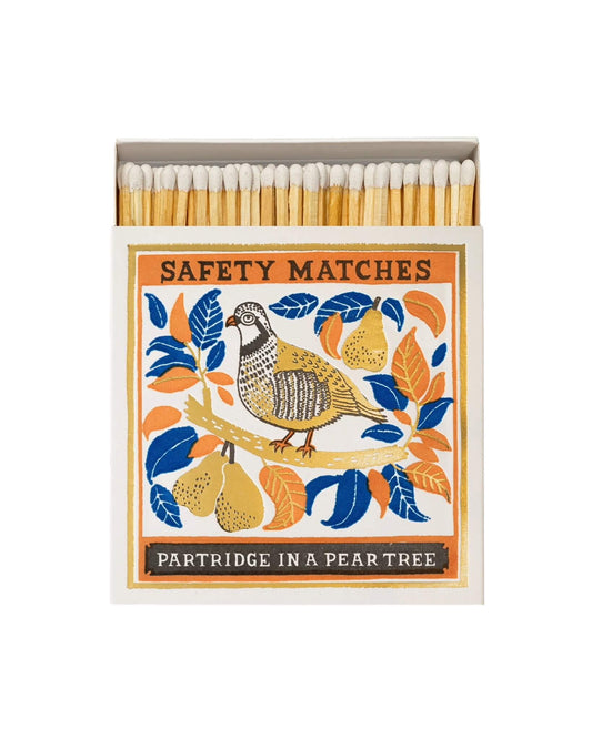 Matches with decorative box featuring a Christmas partridge and pears design on a white background.