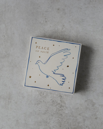 A white matchbox, with a dove illustration and 'peace on earth' lettering.