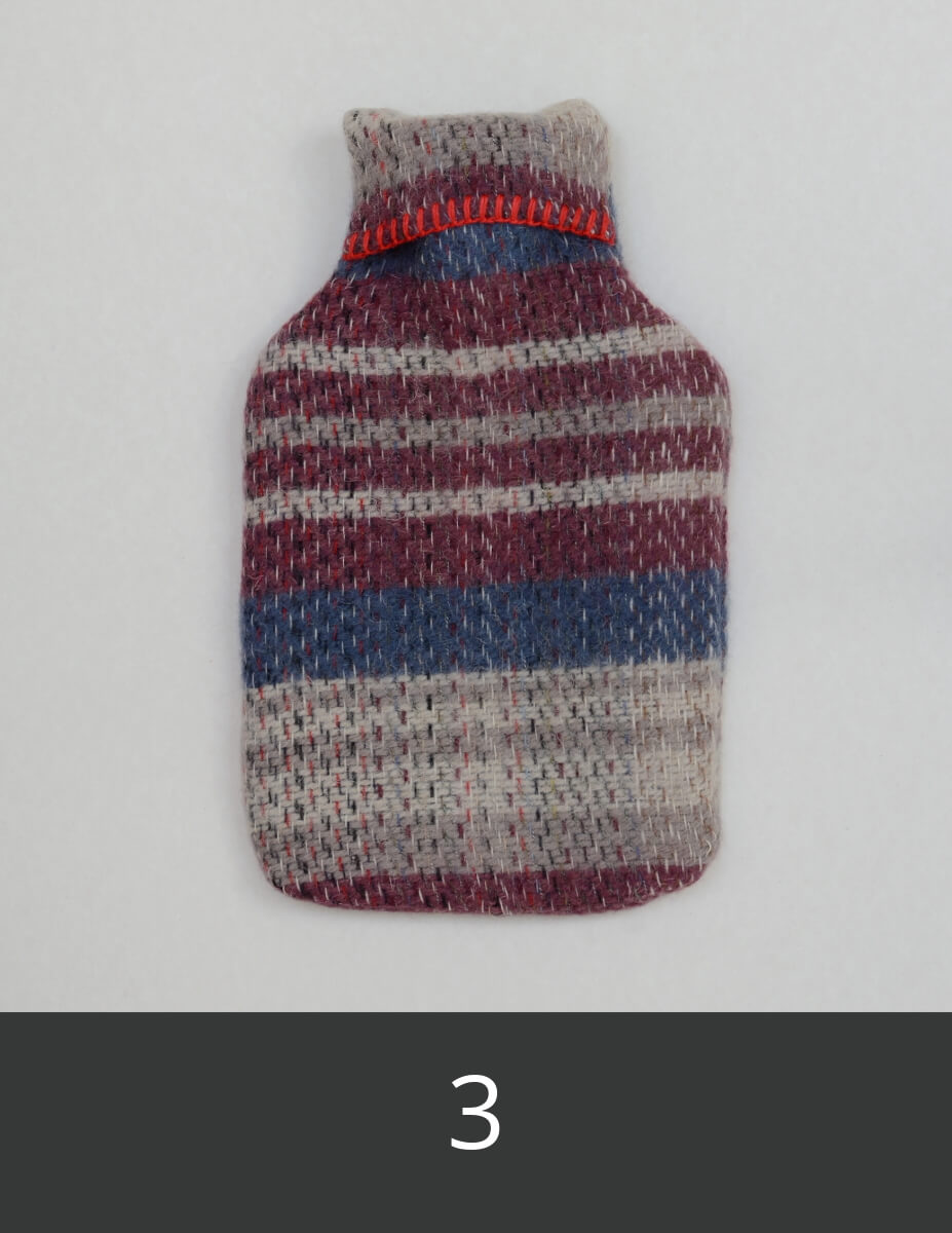 Wool hot water bottle cover with burgundy, pale grey and blue stripes.