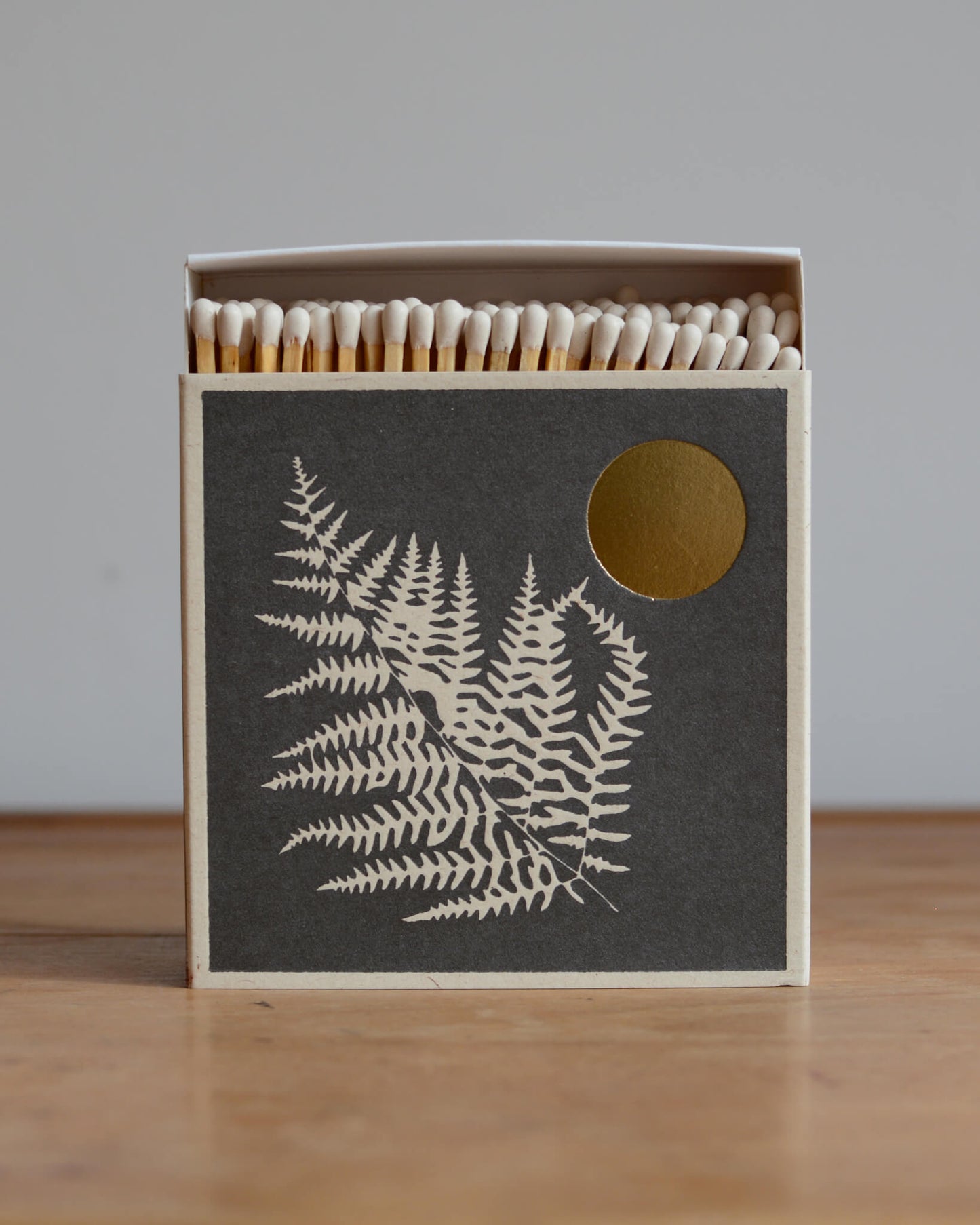 A box of letterpress matches, featuring an illustration of a fern leaf.