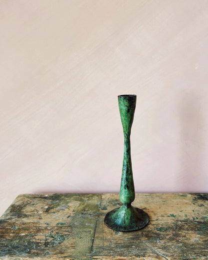 A tall green verdigris candle holder, for taper candles.