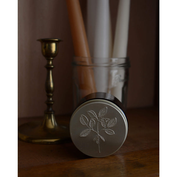 Embossed metal candle lid, featuring a soy bean design.