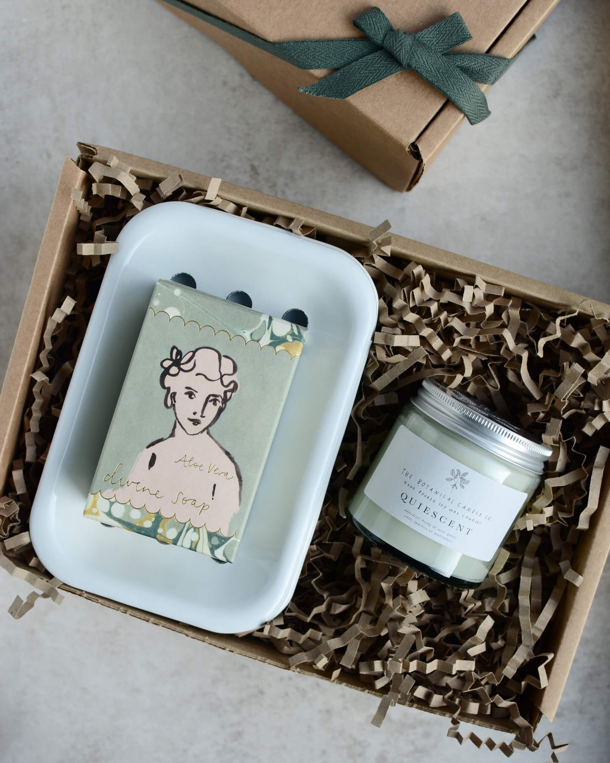 Gift set with a glass candle, green soap, and soap dish, in a gift box.