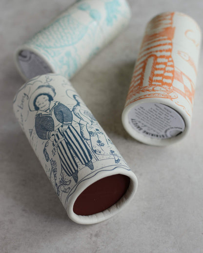 Three cylindrical illustrated match tubes with whimsical illustrations on their side, showing the.match striker panel on the base.