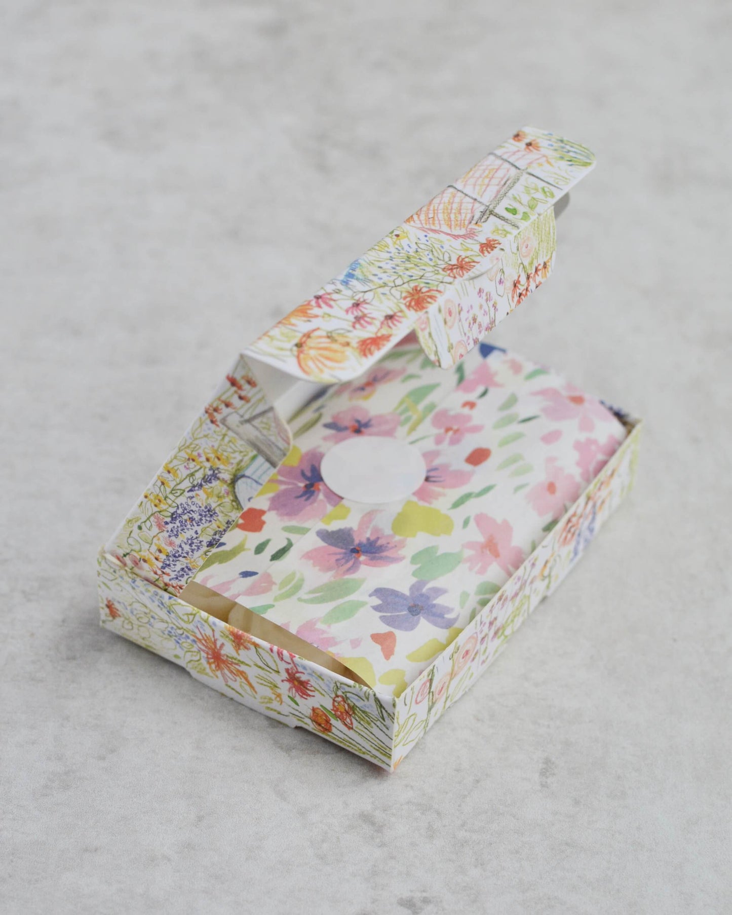 Floral-patterned box of wax melts, on a neutral surface