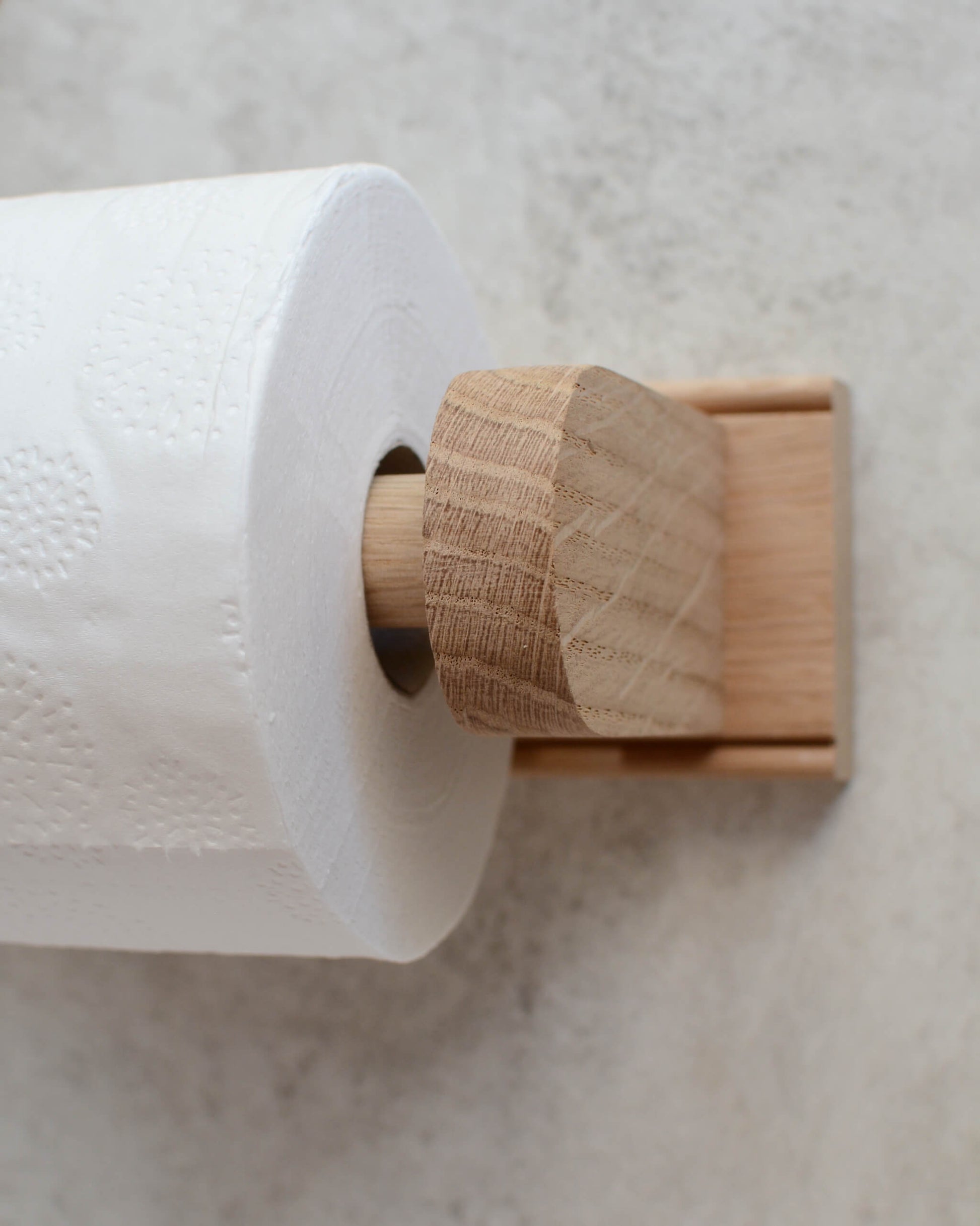Detail shot of a solid oak toilet roll holder, wall mounted
