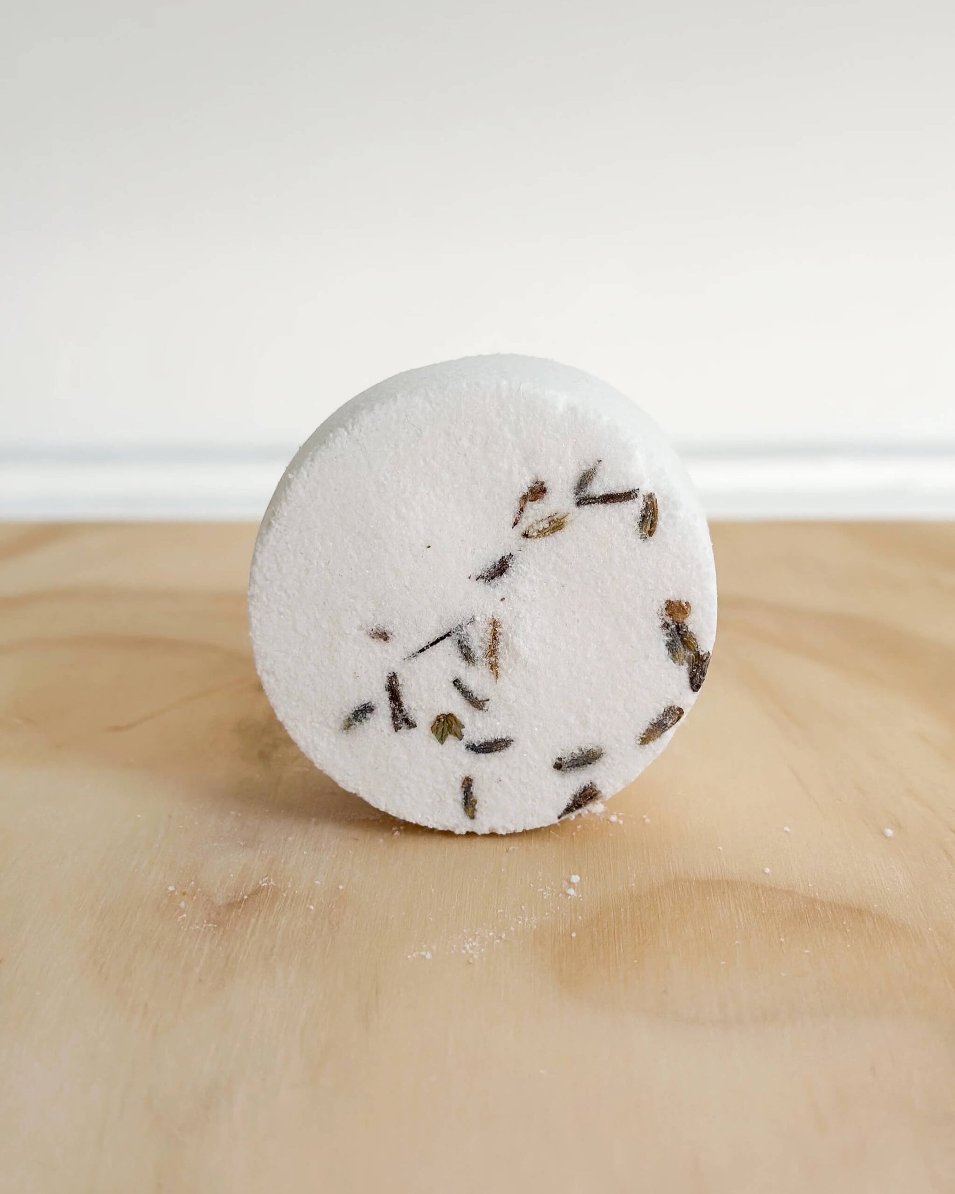 A white shower steamer, with flower petals.