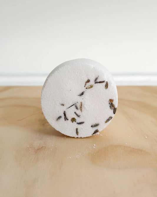 A white shower steamer, with flower petals.