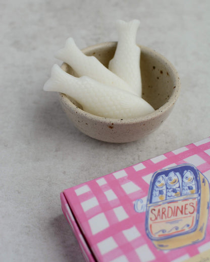 Sea Salt & Spray fish-shaped wax melts in a ceramic dish, next to the illustrated wax melt box.