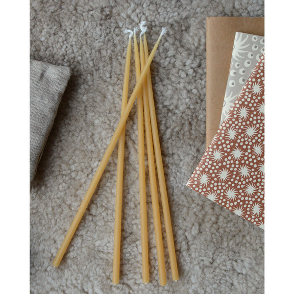 Birthday or celebration beeswax candles, on top of a sheepskin rug.