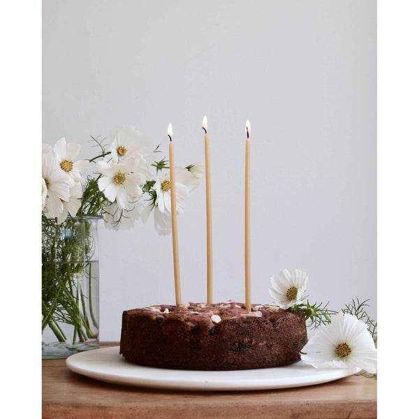 Birthday or celebration beeswax candles, on top of a birthday cake.